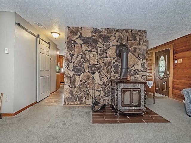 1646 Millers Run Rd, Mount Pleasant Twp Was, PA 15057 - unfurnished living room with a textured ceiling, carpet flooring, a barn door, a wood stove, and baseboards