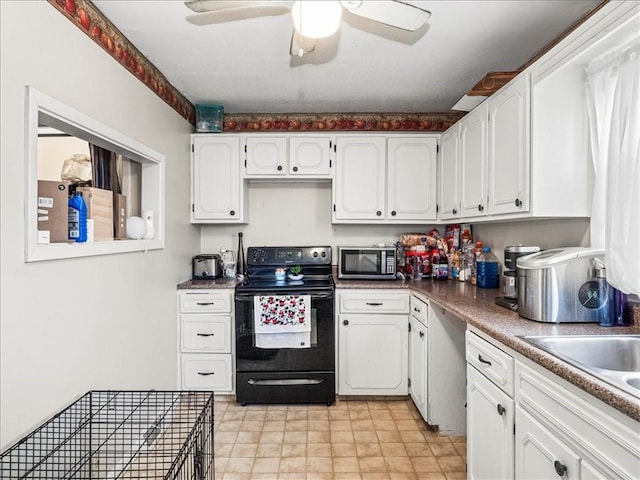 7641 Big Beaver Blvd, Big Beaver, PA 16157 - kitchen featuring black electric range oven, stainless steel microwave, white cabinetry, ceiling fan, and a sink