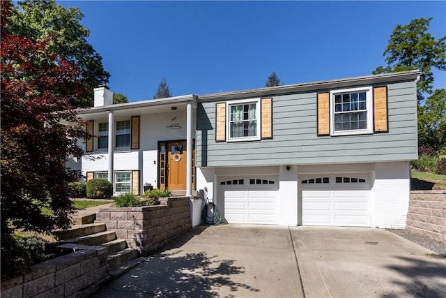 22 Green Crescent Dr, South Strabane, PA 15301 - bi-level home featuring a chimney, an attached garage, and concrete driveway