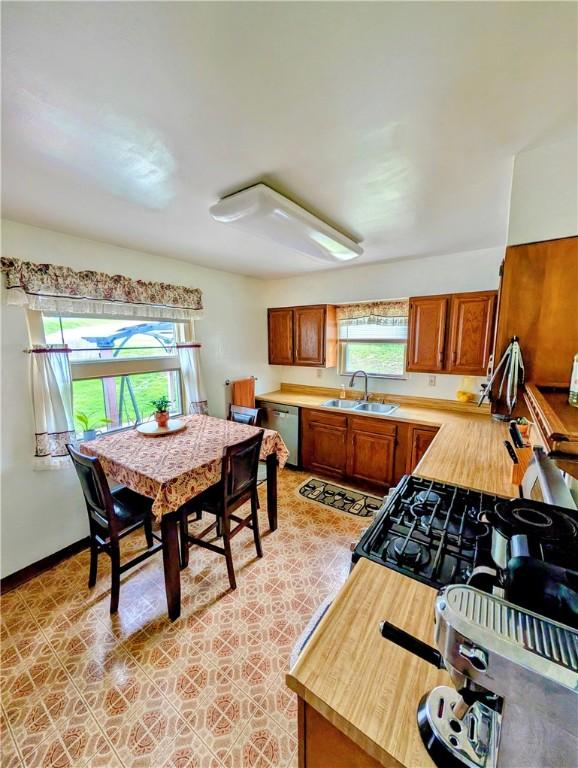 5037 Clifton Dr, Aliquippa, PA 15001 - kitchen with a sink, dishwasher, brown cabinets, and baseboards
