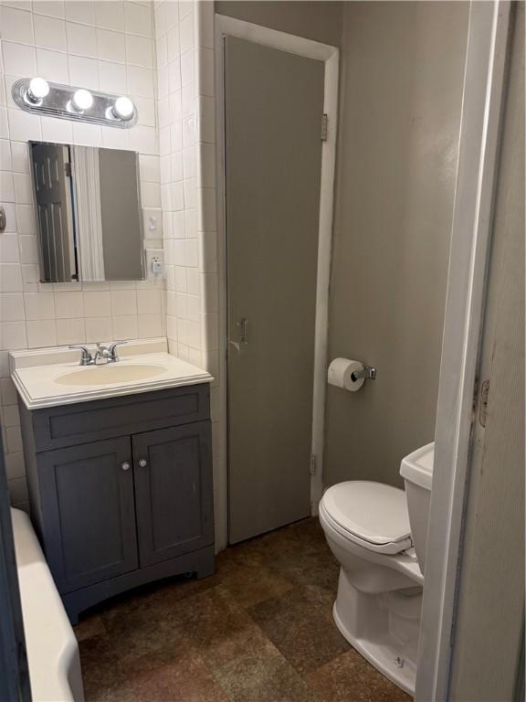 216 Center St, Slippery Rock Boro, PA 16057 - bathroom with vanity, toilet, and decorative backsplash