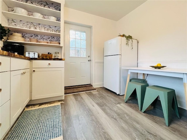 657 Grove St, City Of Greensburg, PA 15601 - kitchen with freestanding refrigerator, light wood-style floors, white cabinetry, and open shelves