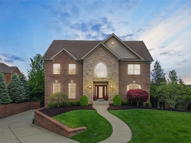 317 Buckingham Dr, Peters Twp, PA 15367 - view of front of home featuring stone siding, a front yard, brick siding, and roof with shingles
