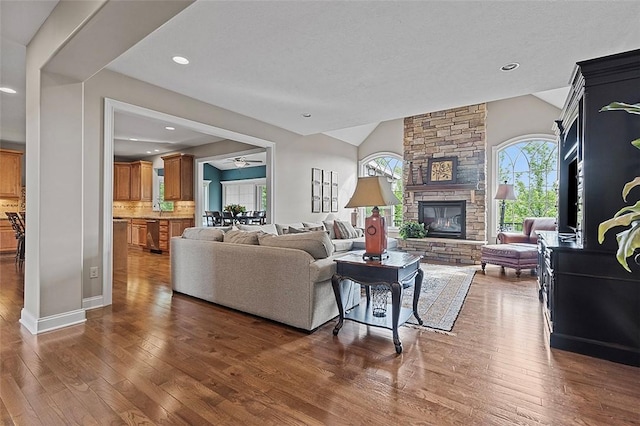 317 Buckingham Dr, Peters Twp, PA 15367 - living area with vaulted ceiling, wood-type flooring, a stone fireplace, baseboards, and recessed lighting