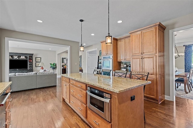 317 Buckingham Dr, Peters Twp, PA 15367 - kitchen with dark wood finished floors, recessed lighting, a kitchen island, stainless steel double oven, and light stone counters