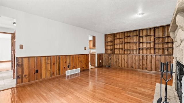 240 La Ray Dr, Center Twp But, PA 16001 - unfurnished living room with wood finished floors, wainscoting, wooden walls, and a fireplace