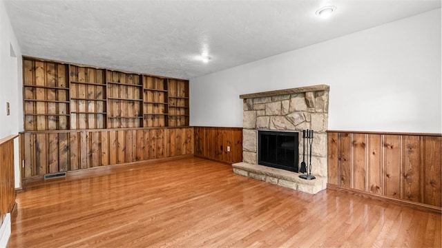 240 La Ray Dr, Center Twp But, PA 16001 - unfurnished living room with wood walls, a wainscoted wall, wood finished floors, and a fireplace
