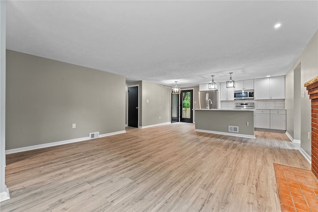 100 Old Legionville Rd, Economy, PA 15005 - unfurnished living room with light wood finished floors, baseboards, and a chandelier