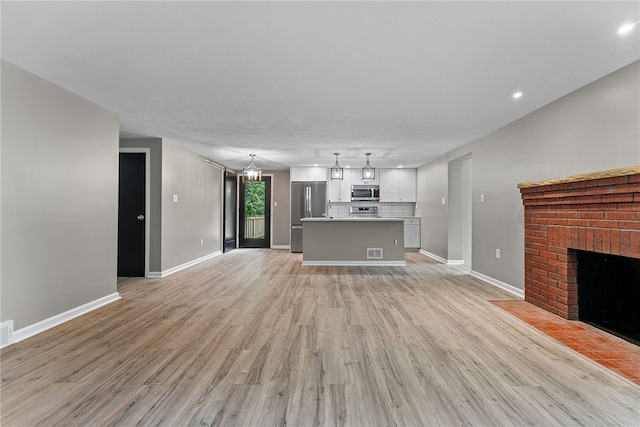 100 Old Legionville Rd, Economy, PA 15005 - unfurnished living room featuring light wood-type flooring, a fireplace, baseboards, and recessed lighting