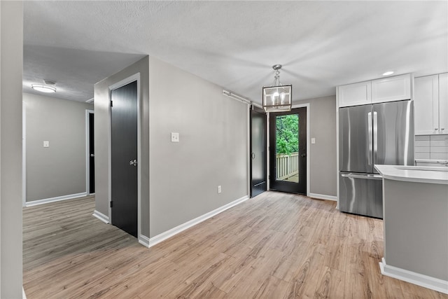 100 Old Legionville Rd, Economy, PA 15005 - kitchen with freestanding refrigerator, light wood-style flooring, white cabinetry, light countertops, and baseboards