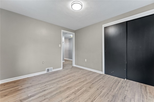 100 Old Legionville Rd, Economy, PA 15005 - unfurnished bedroom with light wood finished floors, a closet, baseboards, and a textured ceiling