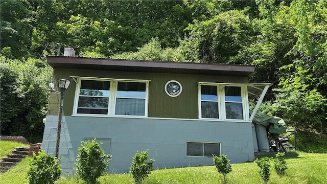 148 Rummel Rd, Bethel Twp, PA 16226 - view of property exterior with a yard, concrete block siding, and a wooded view