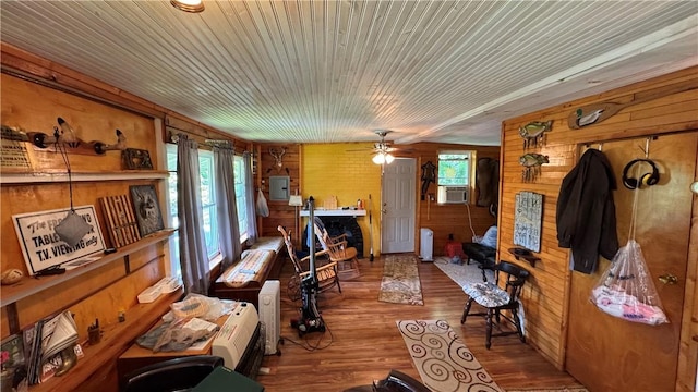 148 Rummel Rd, Bethel Twp, PA 16226 - living room featuring wooden walls, wood finished floors, electric panel, a ceiling fan, and cooling unit