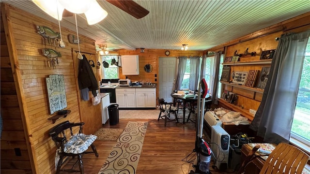 148 Rummel Rd, Bethel Twp, PA 16226 - kitchen with white cabinets, dark wood-style flooring, wooden walls, ceiling fan, and dark countertops