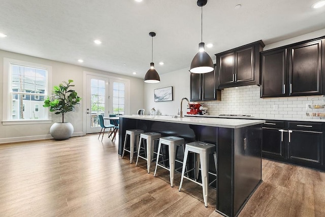 304 Spruce Ln, North Strabane, PA 15317 - kitchen featuring an island with sink, wood finished floors, a breakfast bar area, backsplash, and recessed lighting