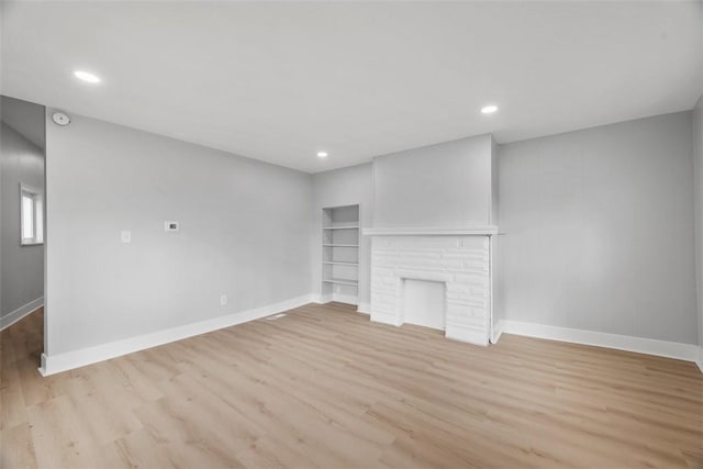 5437 Rosetta St, Garfield, PA 15206 - unfurnished living room featuring baseboards, light wood-type flooring, recessed lighting, and built in features