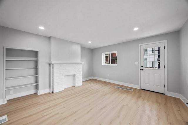 5437 Rosetta St, Garfield, PA 15206 - unfurnished living room featuring light wood-style floors, baseboards, a fireplace, recessed lighting, and built in shelves