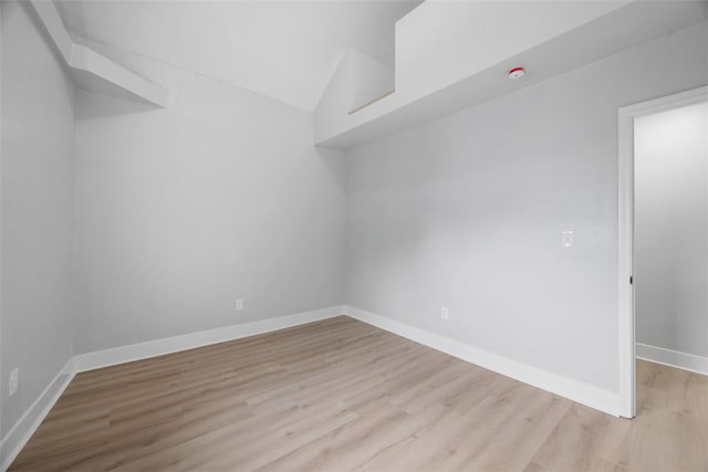 5437 Rosetta St, Garfield, PA 15206 - empty room featuring light wood-style floors, lofted ceiling, baseboards, and a smoke detector