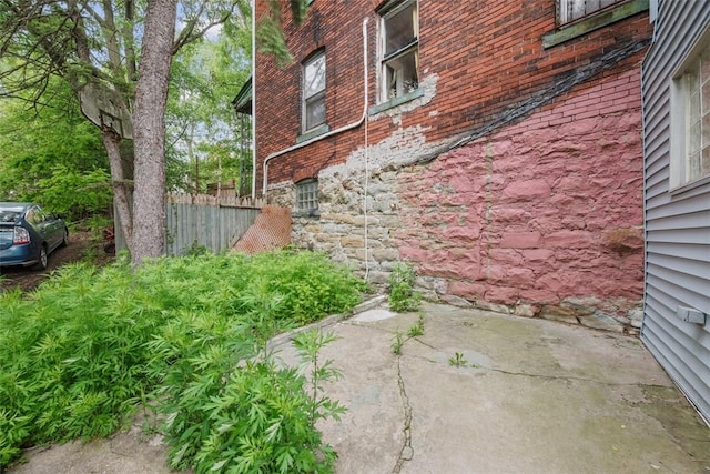 5437 Rosetta St, Garfield, PA 15206 - view of side of home with brick siding, stone siding, and a patio