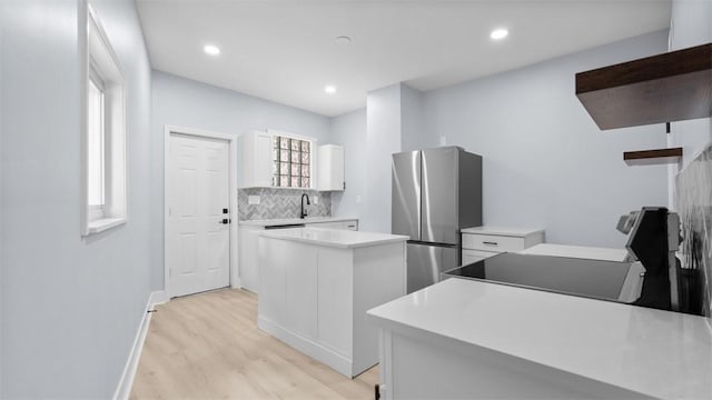 5437 Rosetta St, Garfield, PA 15206 - kitchen featuring freestanding refrigerator, a kitchen island, white cabinets, light wood-style flooring, and recessed lighting