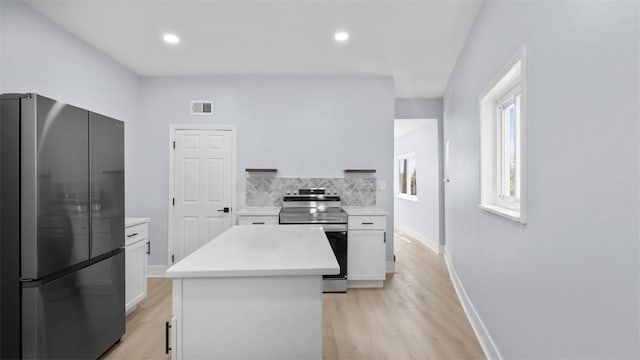 5437 Rosetta St, Garfield, PA 15206 - kitchen with appliances with stainless steel finishes, white cabinets, light countertops, backsplash, and light wood-style flooring