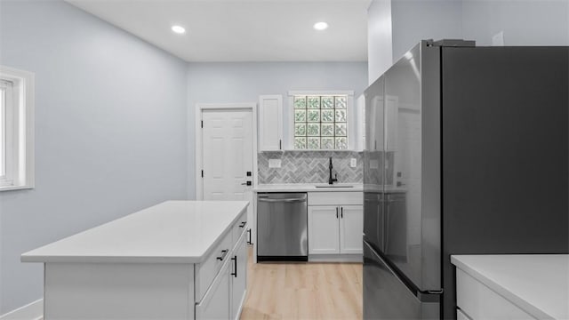 5437 Rosetta St, Garfield, PA 15206 - kitchen with stainless steel appliances, light countertops, white cabinets, light wood finished floors, and backsplash