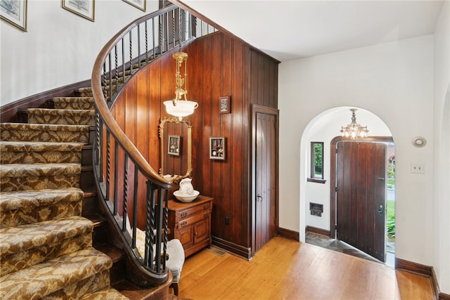 254 Orchard Dr, Mt Lebanon, PA 15228 - entryway with arched walkways, stairway, light wood finished floors, a chandelier, and baseboards