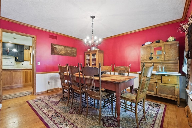 150 Greenfield Rd, Neshannock Twp, PA 16105 - dining space with a chandelier, wood finished floors, crown molding, and a textured ceiling