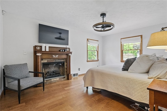 150 Greenfield Rd, Neshannock Twp, PA 16105 - bedroom with wood finished floors, a fireplace, and a textured ceiling