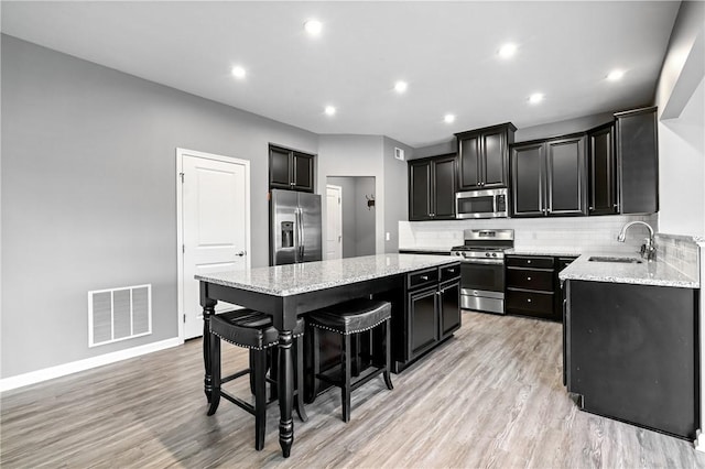3017 Pelican Dr, Middlesex Twp, PA 16059 - kitchen with appliances with stainless steel finishes, a sink, dark cabinets, a center island, and a kitchen bar