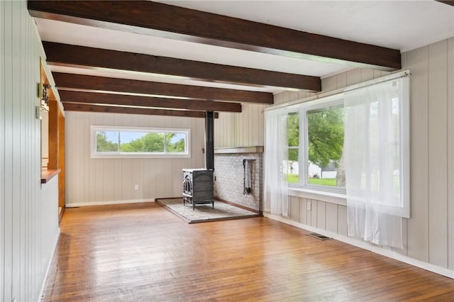 506 E End Road Ext, Bullskin Twp, PA 15425 - unfurnished living room featuring wood-type flooring, a wood stove, beamed ceiling, wooden walls, and baseboards
