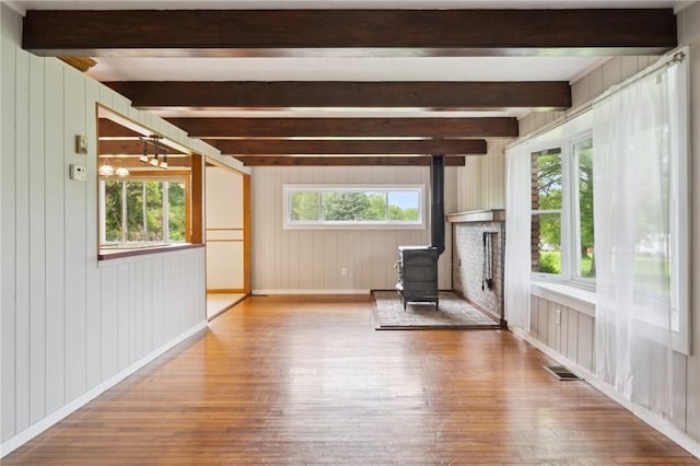 506 E End Road Ext, Bullskin Twp, PA 15425 - unfurnished living room featuring a wood stove, wood-type flooring, wooden walls, beamed ceiling, and baseboards
