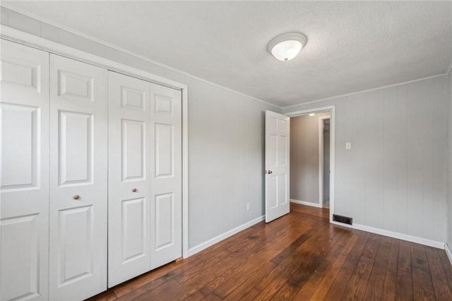 506 E End Road Ext, Bullskin Twp, PA 15425 - unfurnished bedroom with dark wood-style floors, a closet, baseboards, crown molding, and a textured ceiling