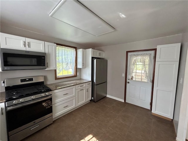 319 Wahl Ave, Evans City Boro, PA 16033 - kitchen with stainless steel appliances, white cabinets, dark stone countertops, and baseboards
