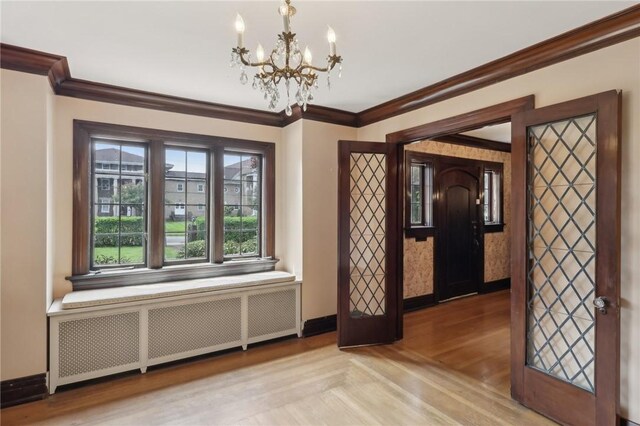 421 E Moody Ave, New Castle/2Nd, PA 16105 - unfurnished dining area featuring radiator heating unit, a chandelier, ornamental molding, and baseboards