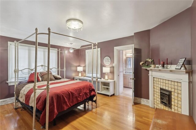 421 E Moody Ave, New Castle/2Nd, PA 16105 - bedroom featuring wood finished floors, a tiled fireplace, baseboards, and ensuite bath
