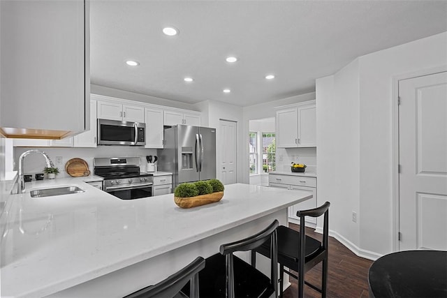153 Birchwood Way, Irwin, PA 15642 - kitchen with stainless steel appliances, a sink, dark wood-style floors, recessed lighting, and white cabinetry