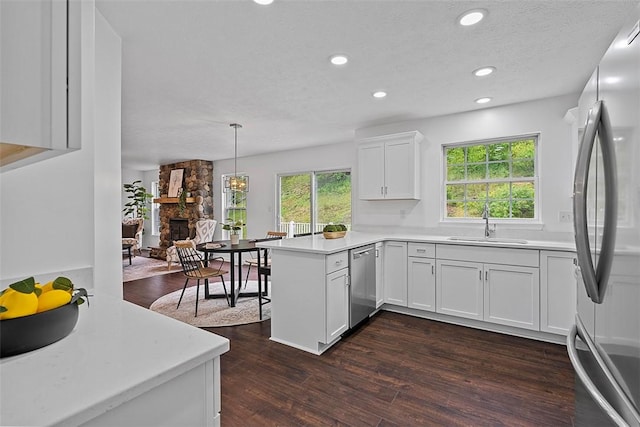 153 Birchwood Way, Irwin, PA 15642 - kitchen with appliances with stainless steel finishes, a stone fireplace, a peninsula, a sink, and dark wood finished floors