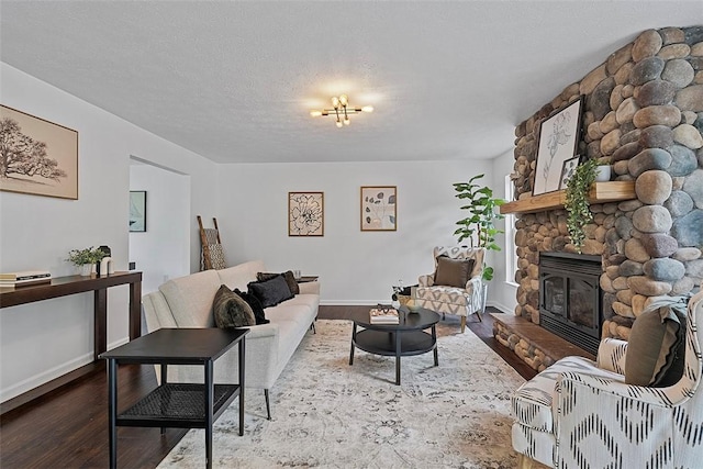 153 Birchwood Way, Irwin, PA 15642 - living room with wood finished floors, a stone fireplace, baseboards, and a textured ceiling