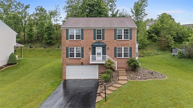 153 Birchwood Way, Irwin, PA 15642 - colonial house with driveway, a garage, brick siding, and a front yard