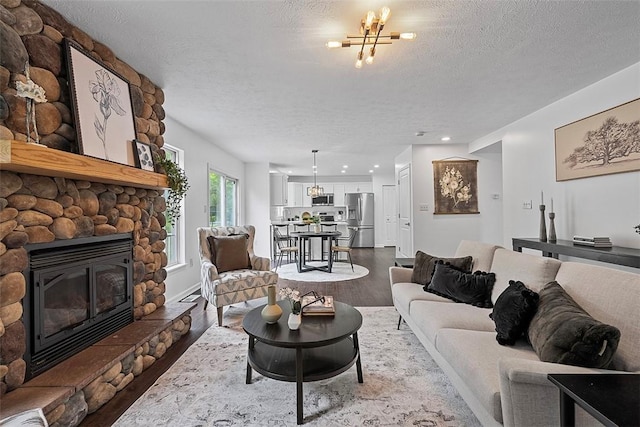 153 Birchwood Way, Irwin, PA 15642 - living area featuring wood finished floors, a fireplace, a textured ceiling, a chandelier, and recessed lighting