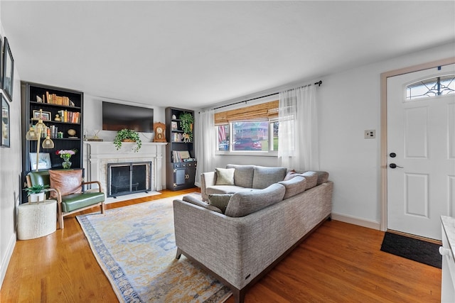 5101 Azalea Dr, Whitehall, PA 15236 - living room featuring healthy amount of natural light, wood finished floors, a fireplace with flush hearth, and baseboards