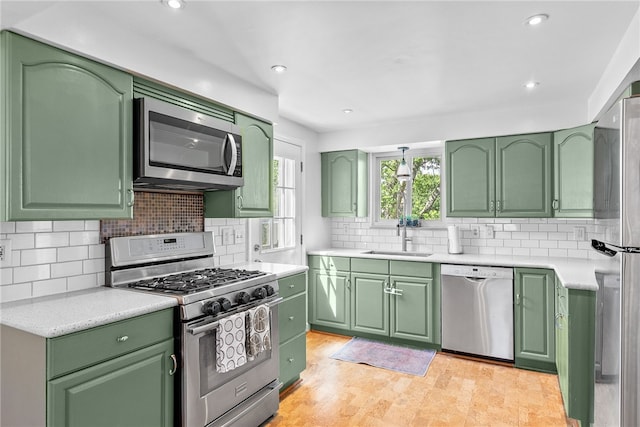 5101 Azalea Dr, Whitehall, PA 15236 - kitchen featuring stainless steel appliances, green cabinets, a sink, light countertops, and tasteful backsplash