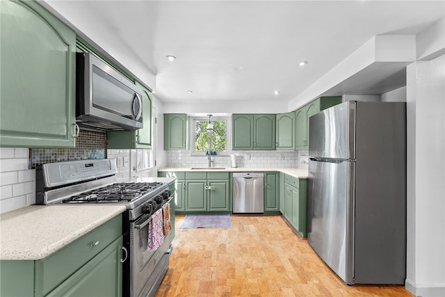 5101 Azalea Dr, Whitehall, PA 15236 - kitchen with stainless steel appliances, green cabinets, a sink, light countertops, and recessed lighting