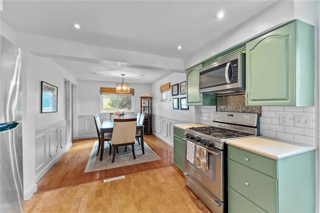 5101 Azalea Dr, Whitehall, PA 15236 - kitchen featuring green cabinetry, appliances with stainless steel finishes, light countertops, light wood-type flooring, and wainscoting