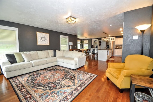1624 Windsor Rd, North Huntingdon, PA 15642 - living area with wood finished floors, a chandelier, and a textured ceiling