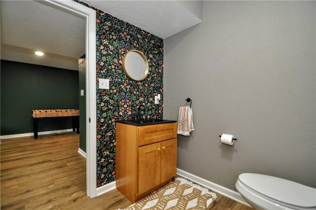 1624 Windsor Rd, North Huntingdon, PA 15642 - bathroom with wallpapered walls, baseboards, vanity, wood finished floors, and toilet