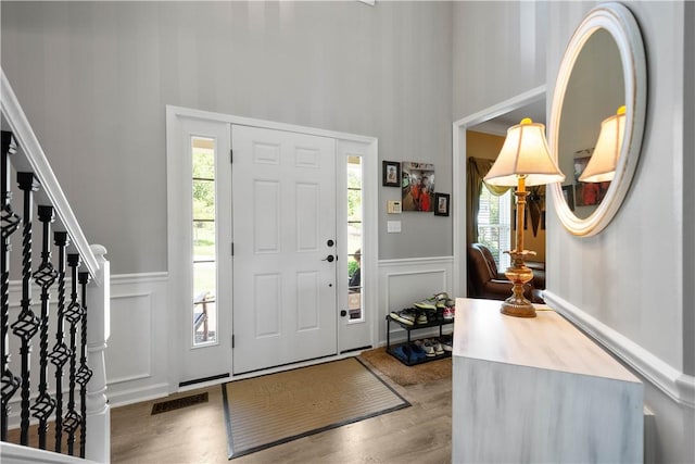 5121 Forest Ridge Dr, South Fayette, PA 15057 - entryway featuring a towering ceiling, a decorative wall, wood finished floors, wainscoting, and stairs