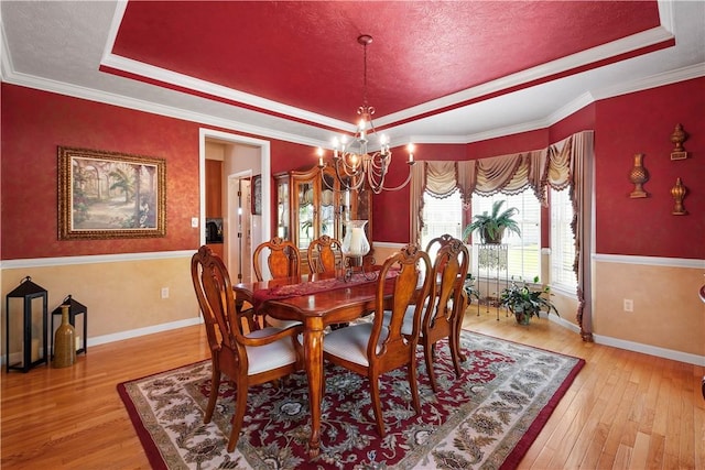 5121 Forest Ridge Dr, South Fayette, PA 15057 - dining area featuring a tray ceiling, a chandelier, light wood-style flooring, crown molding, and a textured ceiling