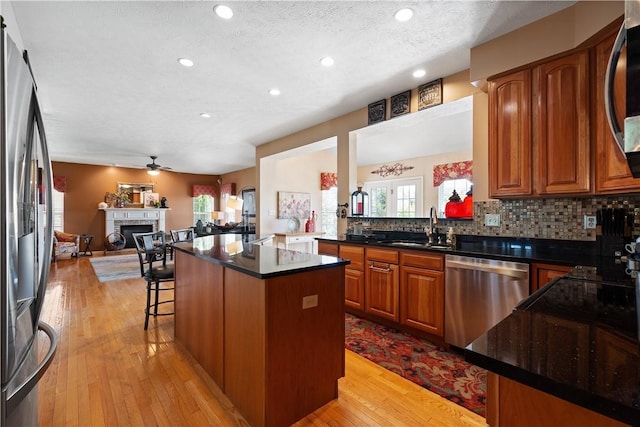 5121 Forest Ridge Dr, South Fayette, PA 15057 - kitchen featuring stainless steel appliances, a sink, a fireplace, open floor plan, and a ceiling fan